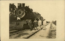 Four Men Standing on Railroad Track Next to Train Engine Locomotives Postcard Postcard