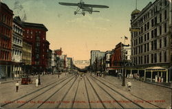 Canal Street, the Broadway of New Orleans, La. showing monoplane flying over street Louisiana Postcard Postcard