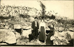 Outdoor photo of men and women near a rock outcrop, early 20th century Postcard