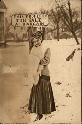 Woman Standing Beside Sign Reading "This Property For Sale. A Bargain" Postcard