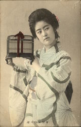 A Japanese woman holding a birdcage. Postcard Postcard