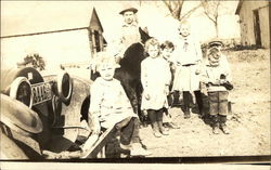 A Man and Children in Front of a Car Postcard