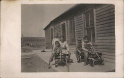 Children on the Back Porch in Toy Wagons Postcard