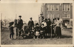 A group of young people pose playfully in front of an apartment building Early 1900's Children Postcard Postcard Postcard