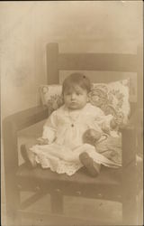 Baby Posing on a Chair with a Doll Postcard