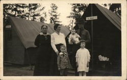 Soldier Posing with Family in front of Tents Postcard