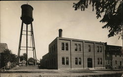 Brick Building Next to Tall Water Tower New Hampton, IA Postcard Postcard Postcard