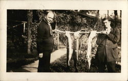 Two Men Holding Pole with Fish Hanging Postcard