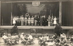 Uniformed People and Others On Stage Beneath "God Bless America" Banner Postcard