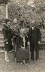 A Woman Sitting in a Chair with Three People Standing Around Her House of David Postcard Postcard Postcard