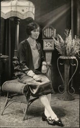 A Woman Sitting on a Chair Postcard