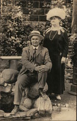 Woman Standing Near Man Seated on Rocks Postcard