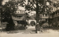 Wide View of Trees, Buildings, "House of David" Archway" & Two Men Postcard