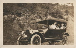 Studebaker on Road Filled with Passengers Postcard