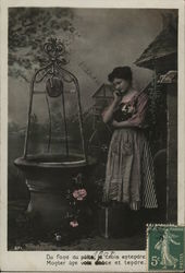 French Woman with Pensive Expression Standing Near Well Postcard