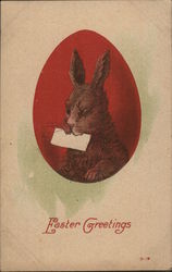 A bunny holding a letter painted on a red Easter egg Postcard