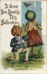 Man with Jack-o-Lantern head kneeling next to female scarecrow with a Jack-O-Lantern head Postcard