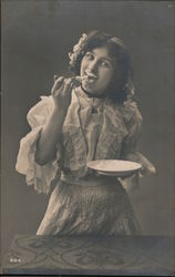 Woman eating from plate Postcard