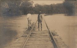 Two Men Standing on Flooded Train Tracks Postcard