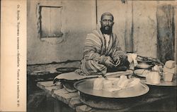 A seated man selling halvah in a shop stall Postcard