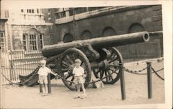 Two Young Boys Standing in Front of a Canon Postcard