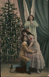 A Merry Christmas Man and Woman in Front of an Angel and a Christmas Tree Angels Postcard Postcard Postcard