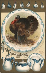 "A Glad Thanksgiving" - Turkey w/ various pieces of blue-trimmed china Postcard