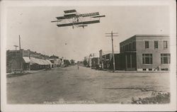 Airplane Flying Along Main Street Postcard