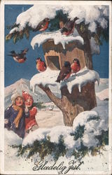 Two children in snow suits looking up into a snow covered tree looking at robins around a bird house Birds Postcard Postcard Postcard