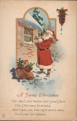 A Joyous Christmas - Santa Standing by a House in the Snow Santa Claus Postcard Postcard Postcard