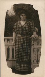 Woman posing for picture outside plaid dress Postcard