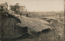 After tanks burst, men standing on remains, probably Nebraska Disasters Postcard Postcard Postcard