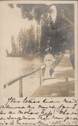 Woman on wooden dock or bridge by water Postcard