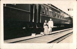 couple in front of a train Postcard