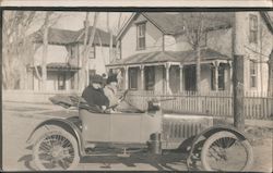 A Man and Woman in an old Car Postcard