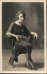 Women in Ornate Dress Sits in a Chair Postcard