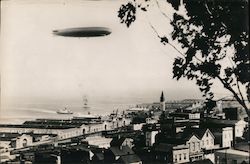 Zeppelin Flying over a Coastal Town Postcard