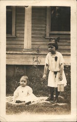 Girl With Large Bow in Hair and Carrying a Pail Stands Next to Toddler on a Blanket Postcard