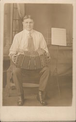 Man sitting on a chair playing the Accordion Performers & Groups Postcard Postcard Postcard