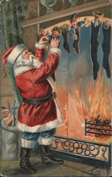 A Merry Christmas- Santa filling stockings hung by the fireplace. Santa Claus Postcard Postcard Postcard