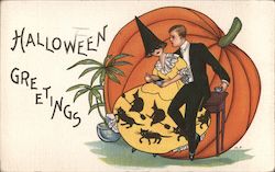 Halloween Greetings - Man with woman dressed in witch garb sitting in front of a huge pumpkin Postcard