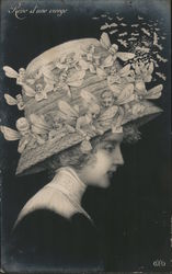 Woman in a hat that has winged men on it Postcard