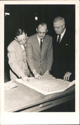 Three Men Looking Over Blueprints Postcard