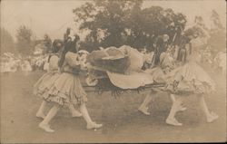 Four young girls in dresses carrying a large cabbage Postcard