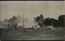 Two People Walking Through Dirt Lot Postcard