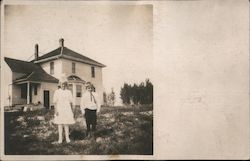 A Young Boy and Girl Standing in the Yard in Front of a House Postcard