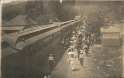 A Train Parked Next to a Huge Crowd Postcard