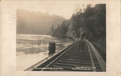 A Woman Standing on Train Tracks Postcard