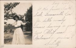 A Woman in a Large Hat Holding a Stick Postcard