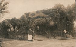 A Woman, Boy and Dog Standing in Front of a Building Postcard